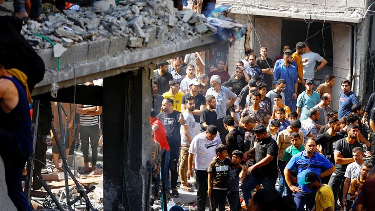 Palestinians watch as others search for casualty at the site of an Israeli strike on a house, in Khan Younis, in the southern Gaza Strip, October 24, 2023. REUTERS/Ibraheem Abu Mustafa..