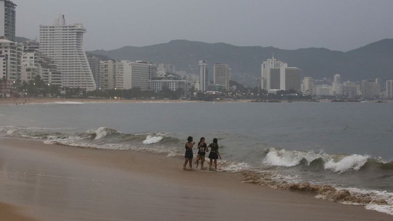 People stand on a beach as Hurricane Otis barrels towards Acapulco, Mexico, October 24, 2023. REUTERS/Javier Verdin
