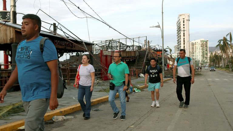 People walk on a street after Hurricane Otis hit, in Acapulco in the Mexican state of Guerrero, Mexico 