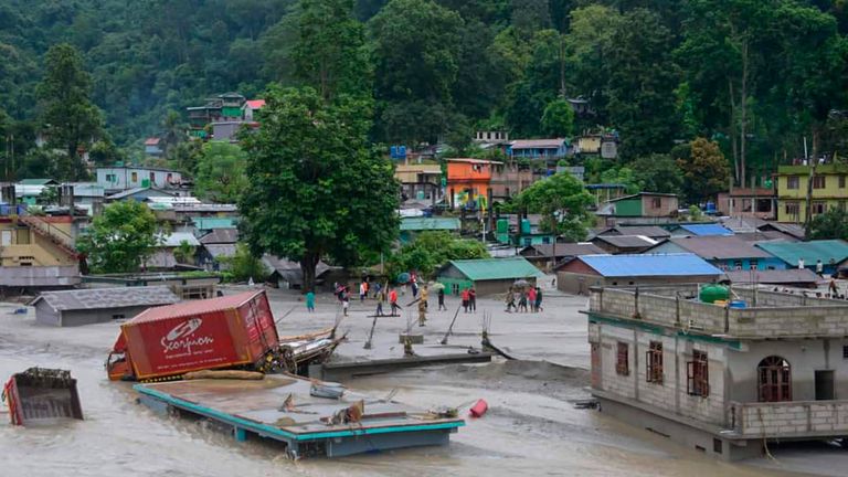 A vehicle that got washed away lies atop a submerged building after flash floods triggered by a sudden heavy rainfall swamped the Rangpo town in Sikkim, India, Thursday, Oct.5. 2023. The flooding took place along the Teesta River in the Lachen Valley of the north-eastern state, and was worsened when parts of a dam were washed away. (AP Photo/Prakash Adhikari)