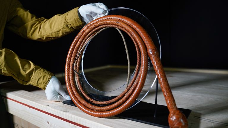 Propstore employee holds a Harrison Ford autographed bullwhip from the 1984 film &#39;Indiana Jones and the Temple of Doom&#39; (estimate £100,000 - 200,000) during a preview for the showbiz memorabilia auction, at the Propstore in Rickmansworth, Hertfordshire. Picture date: Wednesday September 20, 2023.