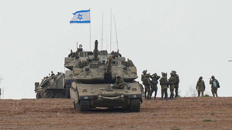 Israeli soldiers are seen in a staging ground near the Israeli Gaza border, southern Israel, Monday, Oct. 9, 2023. . (AP Photo/Ohad Zwigenberg)