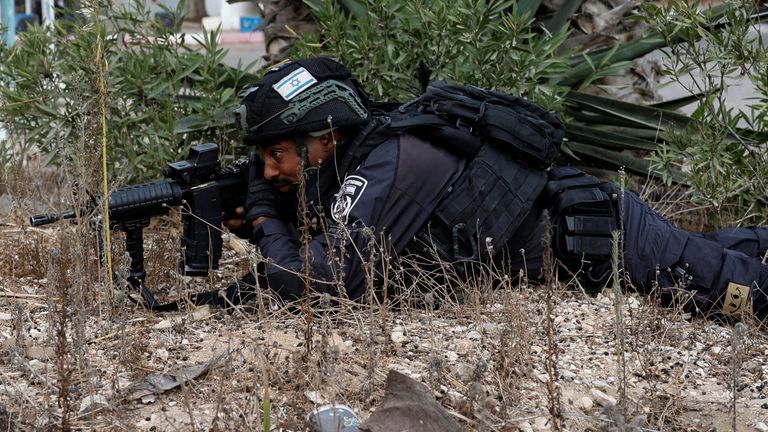 Israeli police take cover while sirens sound as rockets from Gaza are launched towards Israel, near Sderot, southern Israel, October 9, 2023. REUTERS/Amir Cohen