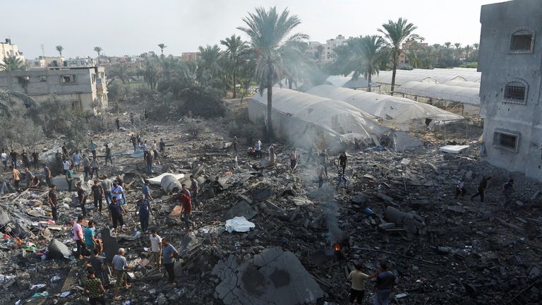 Palestinians gather near fire burning on rubble in the aftermath of Israeli strikes, in Khan Younis in the southern Gaza Strip October 11, 2023. REUTERS/Ibraheem Abu Mustafa