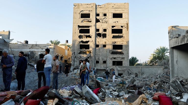 Palestinians look at the destruction of a house in the aftermath of a strike amid the conflict with Israel in Khan Younis, in the southern Gaza Strip, October 12, 2023. REUTERS/Ibraheem Abu Mustafa