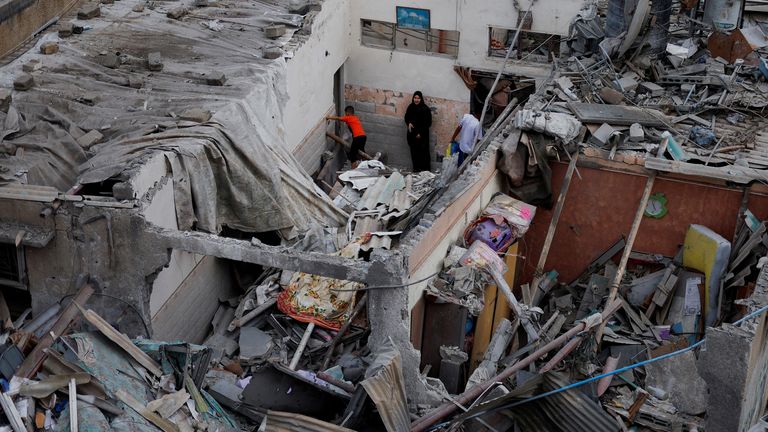 Palestinians check the damage at the site of Israeli strikes on houses, amid the ongoing conflict between Israel and Palestinian Islamist group Hamas, in Khan Younis in the southern Gaza Strip