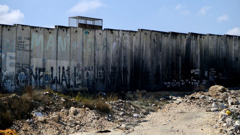 A huge wall with a series of fortified checkpoints. that separates the West Bank from Israel