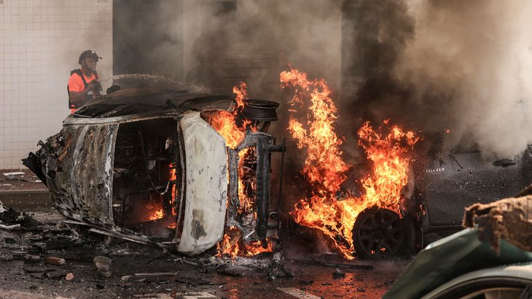 07 October 2023, Israel, Ashkelon: People try to extinguish fire on cars following a rocket attack from Gaza. Palestinian militants in Gaza unexpectedly fired dozens of rockets at Israeli targets early on Saturday, the Israeli army said. Photo by: Ilia Yefimovich/picture-alliance/dpa/AP Images


