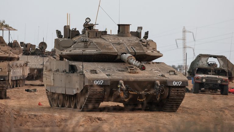 An Israeli tank and military vehicles are seen near Israel&#39;s border with the Gaza Strip, in southern Israel