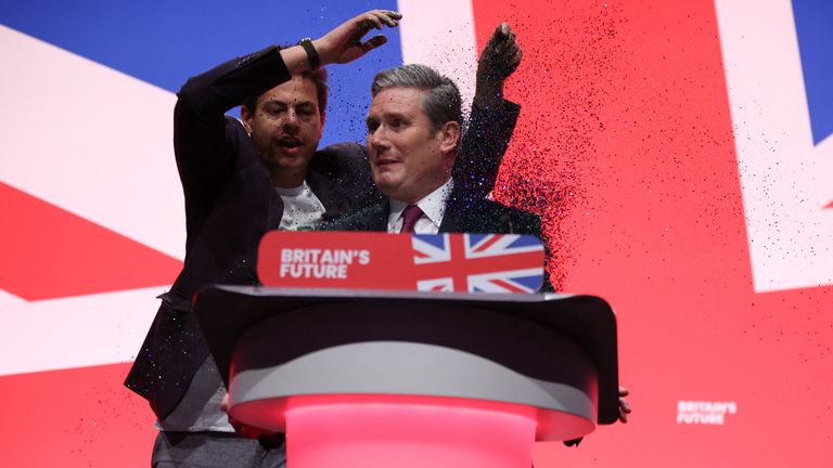 A protester stands next to Britain&#39;s Labour Party Leader Keir Starmer at Britain&#39;s Labour Party annual conference in Liverpool, Britain, October 10, 2023. REUTERS/Phil Noble
