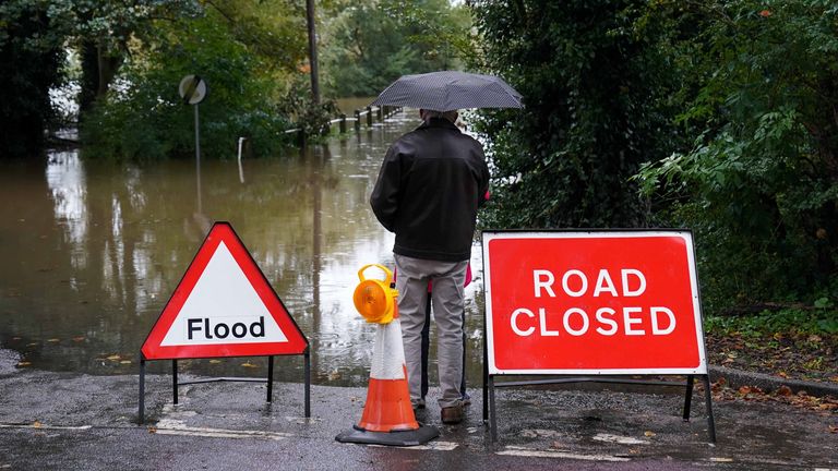 Local residents observe the flooded Carlton Ferry Lane in the village of Collingham in Nottinghamshire after Storm Babet passed through the area