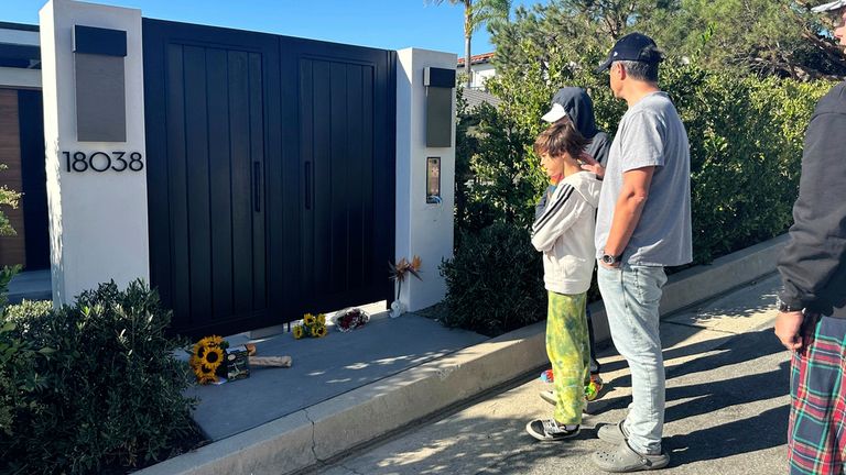 Fans gather outside Matthew Perry&#39;s LA home to lay flowers. Pic: AP