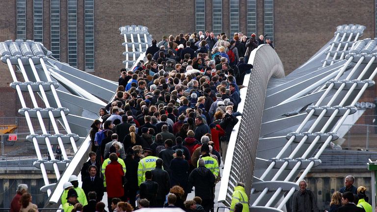 Members of the public stream across the Millennium Bridge in London February 22, 2002. The Millennium Bridge in London is reopening on Friday after two years of engineering work to stop it wobbling. The 18.2million pound bridge, central London&#39;s first new river crossing for more than a century, was opened on June 10, 2000 but was shut three days later due to excessive wobbling. REUTERS/Stephen Hird SH/ps