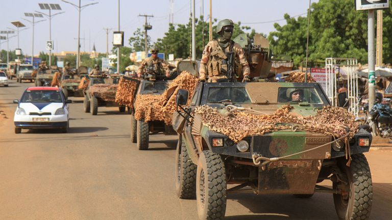 A convoy of French troops based in Niger drives by as they prepare to leave Niger, in Niamey