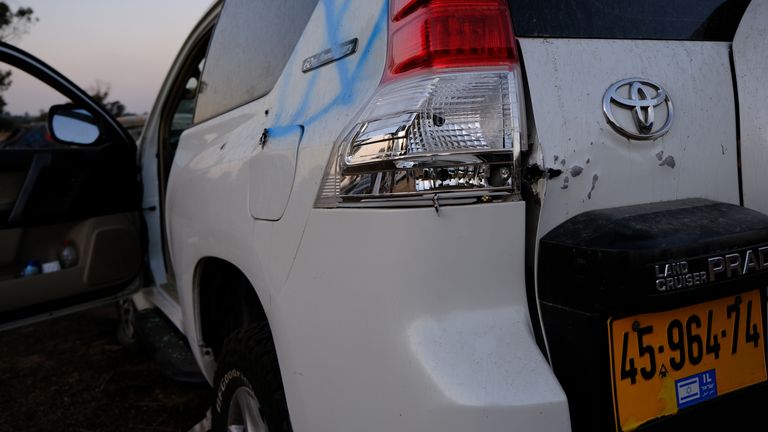Cars are seen pockmarked with bullet holes