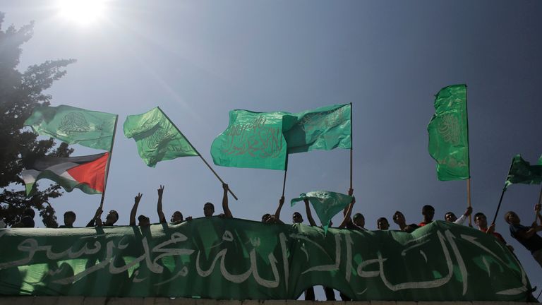 Palestinians wave Hamas and Palestinian (L, bottom) flags during a rally celebrating what they say was a victory by Palestinians in Gaza over Israel following a ceasefire, in the West Bank city of Hebron August 29, 2014. 