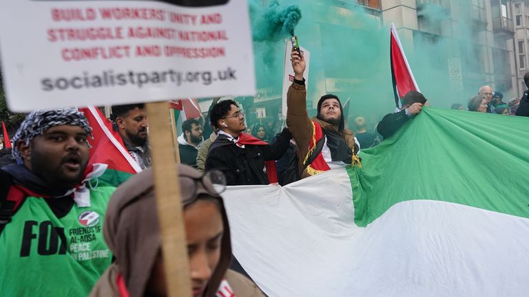 People let off green smoke flares during the pro-Palestine march 