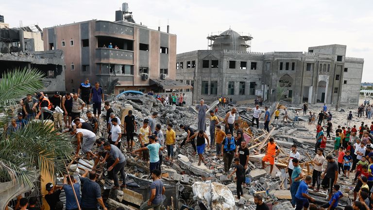 Palestinians walk among the rubble of a building destroyed in Israeli strikes, in the southern Gaza Strip October 9, 2023. REUTERS/Ibraheem Abu Mustafa
