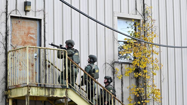 CORRECTS THAT THE OFFICERS ARE WITH THE FREDERICK COUNTY SHERIFF&#39;S OFFICE - Officers with the Frederick County Sheriff&#39;s Office SWAT Team search for suspect Pedro Argote at the former Garden State Tannery plant in Williamsport, Md. on Saturday, Oct. 21, 2023. Washington County Sheriff Brian Albert said authorities are ...actively working... to apprehend 49-year-old Pedro Argote for the ...targeted attack... of Maryland Circuit Court Judge Andrew Wilkinson. (Ric Dugan/The Frederick News-Post via AP)