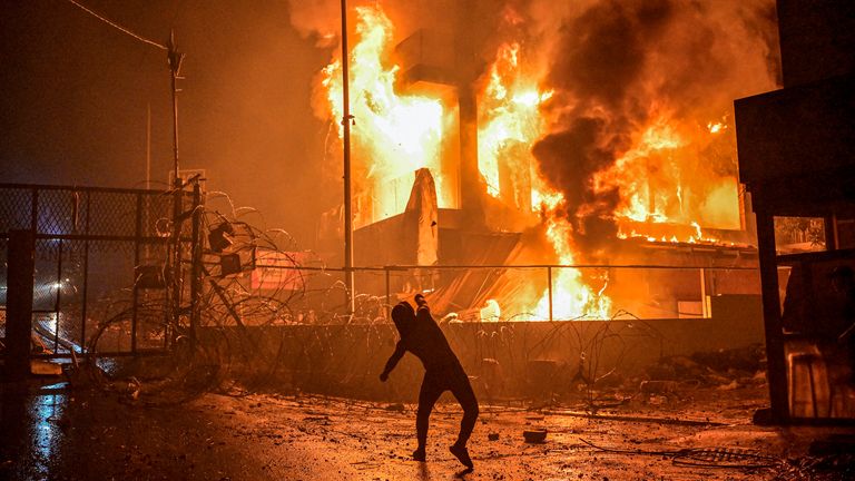 A protestor hurls stones at a burning building just outside the US Embassy in Lebanon following the bombing of the Ahli Arab Hospital in Gaza
Pic:DPA/AP