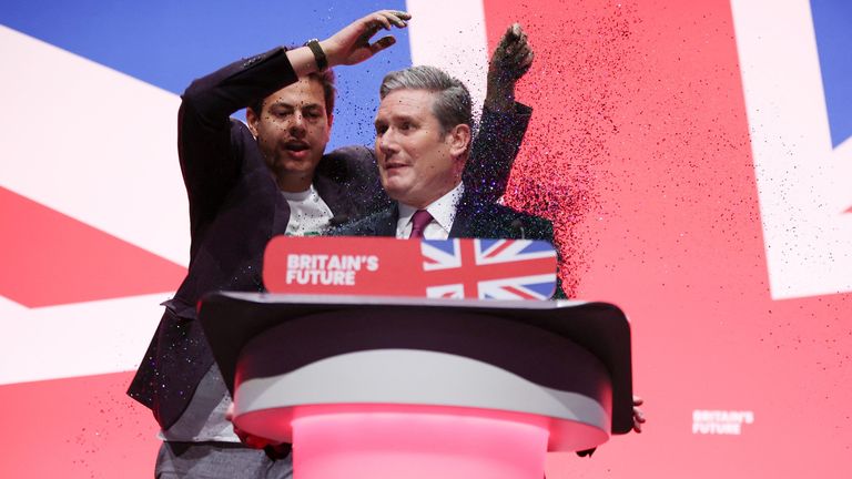 A protester stands next to Britain's Labour Party Leader Keir Starmer at Britain's Labour Party annual conference in Liverpool, Britain, October 10, 2023. REUTERS/Phil Noble