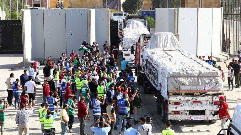 Egyptian volunteers celebrate as the trucks carrying humanitarian aid drive through the Rafah crossing  on Saturday