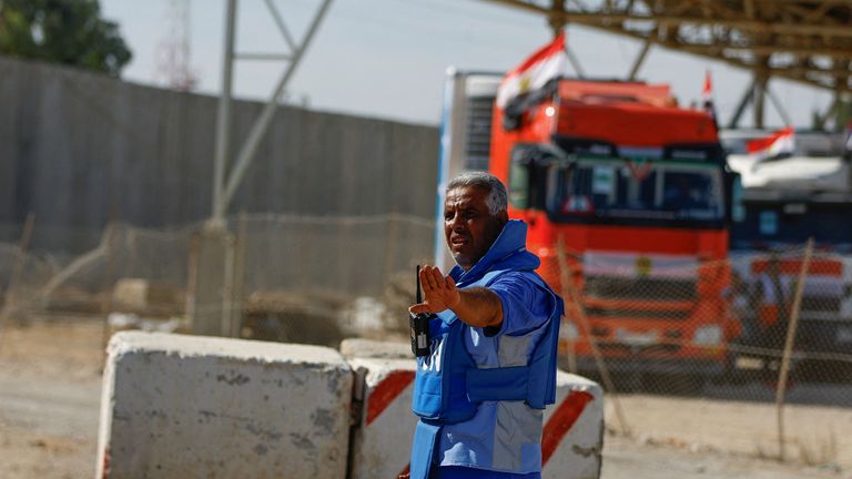 Un employé de l'ONU photographié au terminal de Rafah alors que des camions transportant de l'aide arrivent du côté palestinien de la frontière