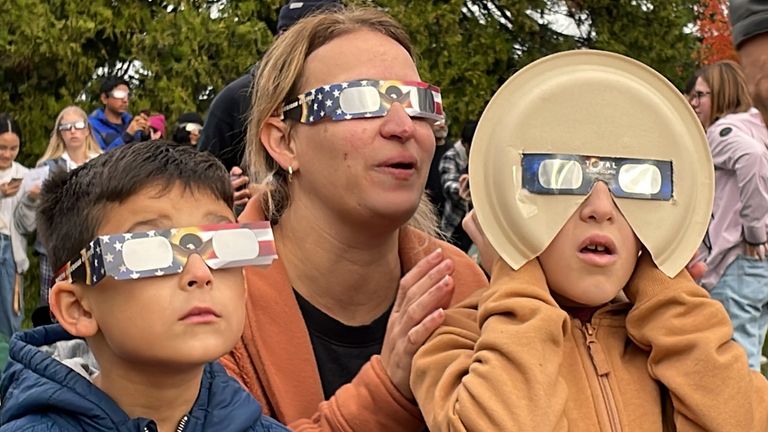 Samia Harboe, her son Logan and her friend&#39;s son wear eclipse glasses during totality of the annular solar eclipse in Eugene, Ore., on Saturday, Oct. 14, 2023. Her family came with glasses they&#39;d made for the 2017 total eclipse and said they were excited to see another one.  (AP Photo/Claire Rush)