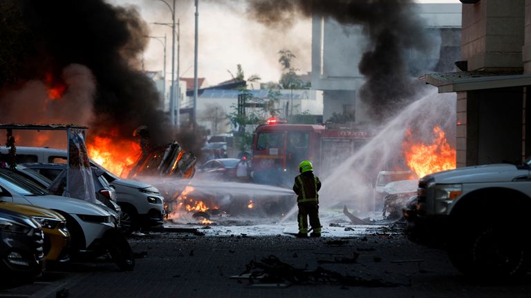 An emergency personnel works to extinguish the fire after rockets are launched from the Gaza Strip, as seen from the city of Ashkelon, Israel October 7, 2023. REUTERS/Amir Cohen TPX IMAGES OF THE DAY
