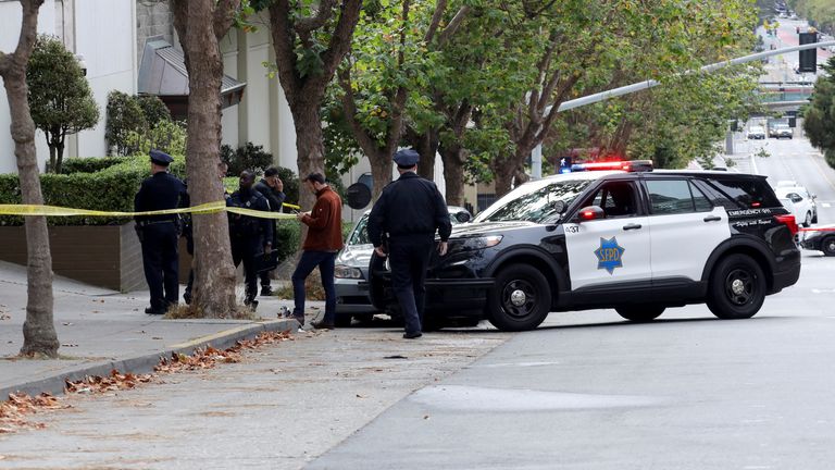 Law enforcement members stand on the street near the Chinese consulate