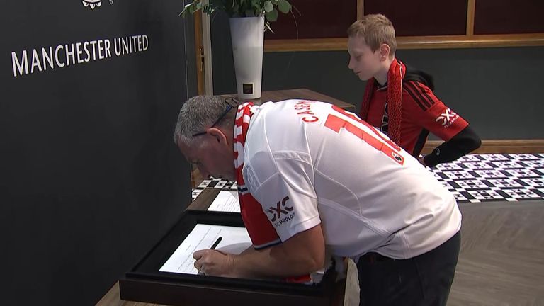 Fans sign a book of condolence for Sir Bobby Charlton