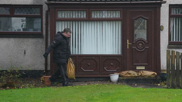 A resident puts sand bags outside his door as he leaves his house on River Street in Brechin. The UK is bracing for heavy wind and rain from Storm Babet, the second named storm of the season. A rare red weather warning stating there is a "risk to life" has been issued for parts of Scotland as the storm is expected to batter the UK on Thursday. Picture date: Thursday October 19, 2023.