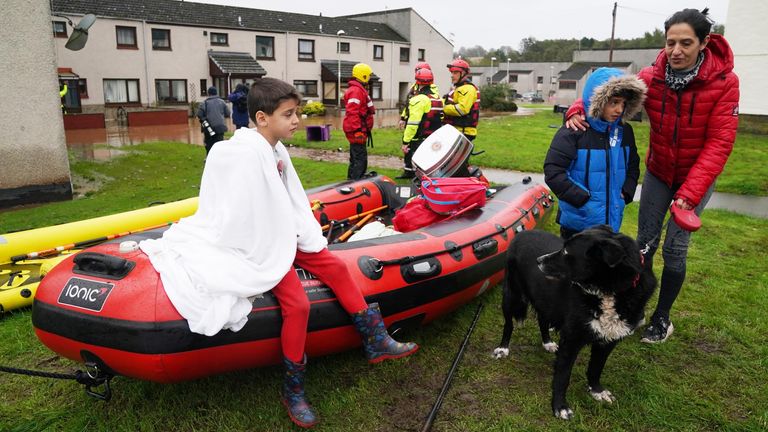 A boy sits on a rescue boat in Brechin, Scotland, as Storm Babet  