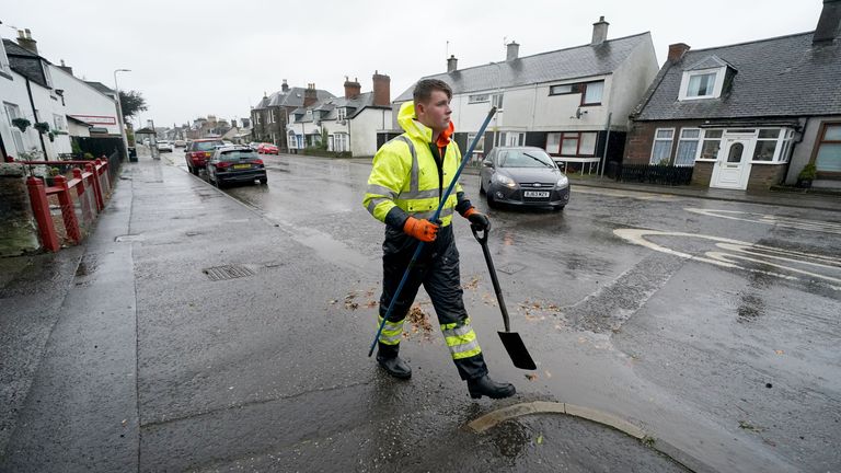 A workman clears the drains in the village of Edzell, Scotland, ahead of Storm Babet