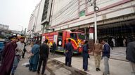 People gather in front of a commercial high-rise building in Karachi, Pakistan, Nov. 25, 2023. At least 10 people were killed and 22 injured in the blaze at RJ Mall on Rashid Minhas Road in Karachi. (AP Photo/Fareed Khan)