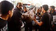 A Palestinian man holds a casualty as they rush into the hospital, following an Israeli strike in Khan Younis, in the southern Gaza Strip