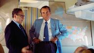 Richard Nixon and Henry Kissinger stand on Air Force One during their voyage to China in 1972