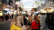 FILE PHOTO: People with shopping bags walk along Oxford Street illuminated with Christmas lights in London, Britain, November 13, 2021. REUTERS/Henry Nicholls/File Photo