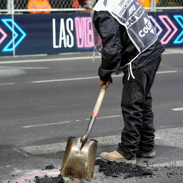 A worker fills in a hole before the start of the second practice session for the Formula One Las Vegas Grand Prix auto race, Friday, Nov. 17, 2023, in Las Vegas. (AP Photo/Nick Didlick)