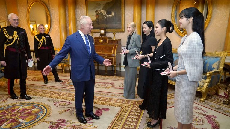 Britain's King Charles III, left. presents the members of the K-Pop band Blackpink, from background, fourth right, Rose (Roseanne Park), Jisoo Kim, Jennie Kim, and Lisa (Lalisa Manoban), with Honorary MBEs, Member of the Order of the British Empire, during a special investiture ceremony in the presence of the South Korea's President Yoon Suk Yeol, and his wife, Kim Keon Hee, at Buckingham Palace, in London, Wednesday, Nov. 22, 2023. (Victoria Jones/Pool Photo via AP)