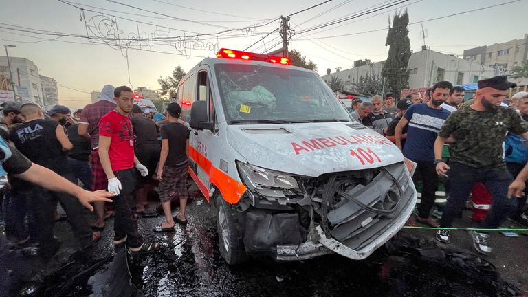 Palestinians look at a damaged ambulance outside the Shifa hospital