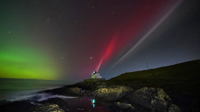 The aurora borealis (left) alongside a strong thermal emission velocity enhancement, a rare aurora-like phenomenon named a STEVE in 2016 by scientists in Canada, can be seen over Bamburgh castle, in Northumberland on the North East coast of England. The atmospheric optical phenomenon is caused by a flowing ribbon of hot plasma breaking through into the earth&#39;s ionosphere, appearing in the sky as a purple, red and white arc. Picture date: Sunday November 5, 2023. PA Photo. See PA story WEATHER Aurora. Photo credit should read: Owen Humphreys/PA Wire 