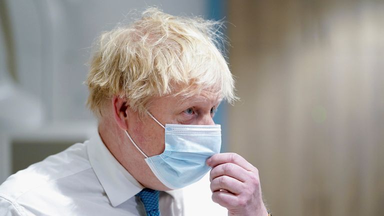  Boris Johnson adjusts his mask during his visit to the Kent Oncology Centre at Maidstone Hospital in Kent, Britain, February 7, 2022. Gareth Fuller/Pool via REUTERS