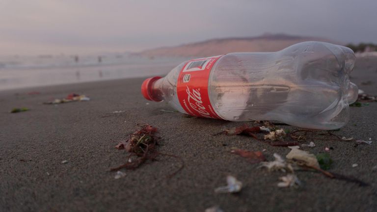 EMBARGOED TO 0001 TUESDAY AUGUST 23 Undated Surfers Against Sewage handout photo of of plastic Coca-Cola bottle on a beach. A dozen companies are responsible for 70% of the branded packaging pollution found on UK beaches and the environment, charity Surfers Against Sewage has said. Issue date: Tuesday August 23, 2022.