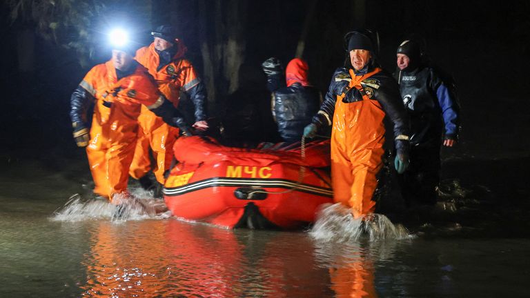 Rescuers use a boat while evacuating local residents from a flooded street following a storm warning in Yevpatoriya, Crimea 