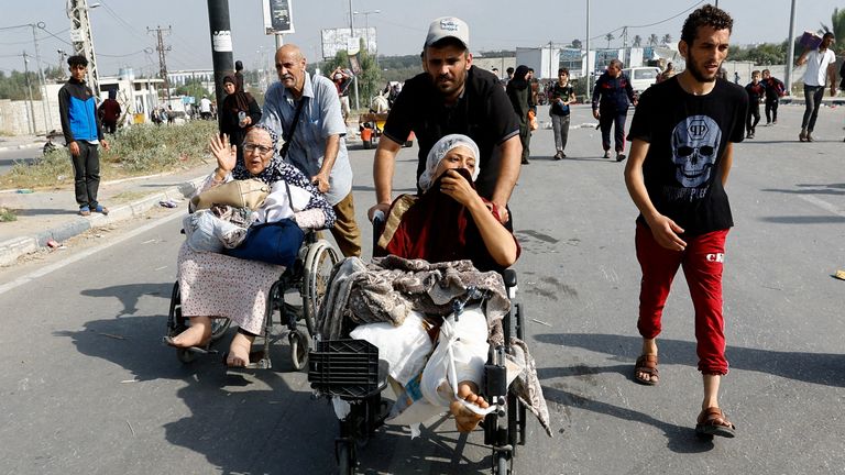 A Palestinian woman, who was injured in an Israeli strike and was staying at Al Shifa hospital, moves southward after fleeing north Gaza