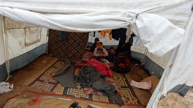 Palestinian children sit in a tent following a rainfall, amid the ongoing conflict between Israel and Palestinian Islamist group Hamas, in Khan Younis in the southern Gaza Strip, November 19, 2023. REUTERS/Mohammed Salem