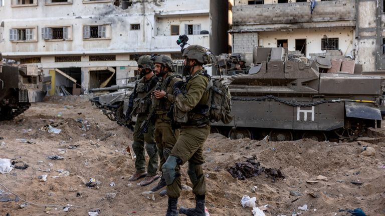 Israeli soldiers stand amid the rubble in Gaza