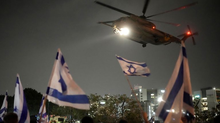 People waves Israeli flags as a helicopter carrying hostages released from Gaza by Hamas arrives at the helipad of the Schneider Children&#39;s Medical Center in Petah Tikva, Israel, Sunday Nov. 26, 2023. The cease-fire between Israel and Hamas was back on track Sunday as the militants freed 17 more hostages, including 14 Israelis and the first American, in exchange for 39 Palestinian prisoners in a third set of releases under a four-day truce. (AP Photo/Leo Correa)