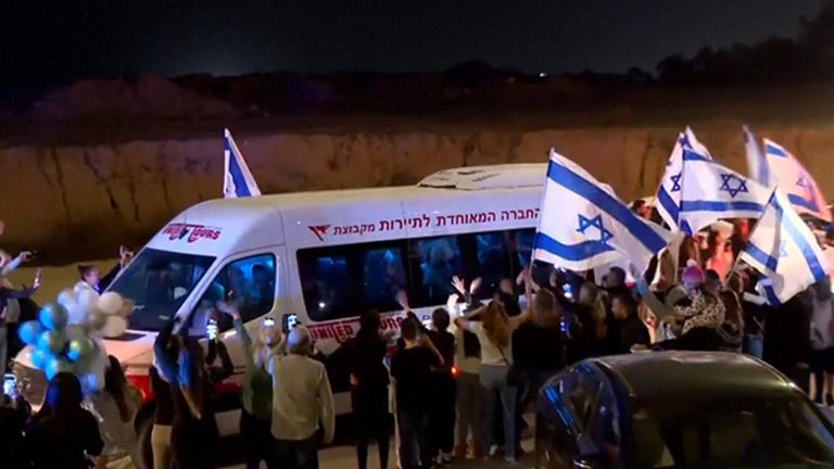 Hundreds of Israelis draped in flags cheered the convoy of released hostages as they arrived from the Gaza Strip 